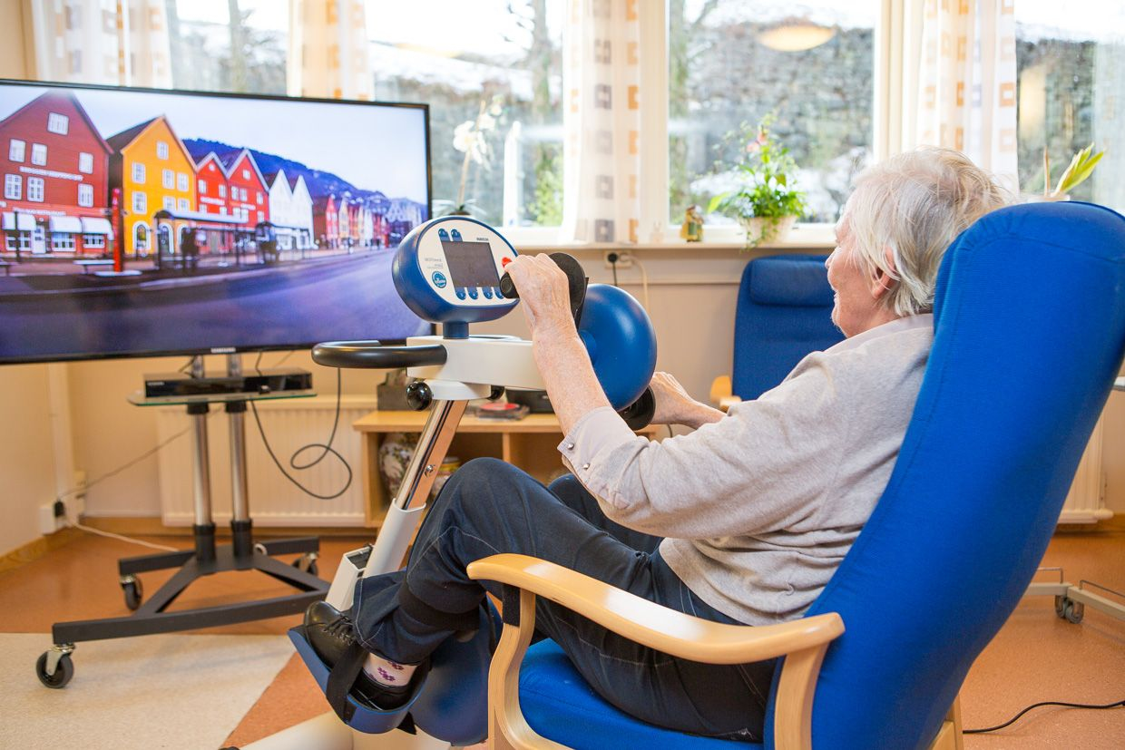 Woman bicycling and watching videos from Motiview on a tv